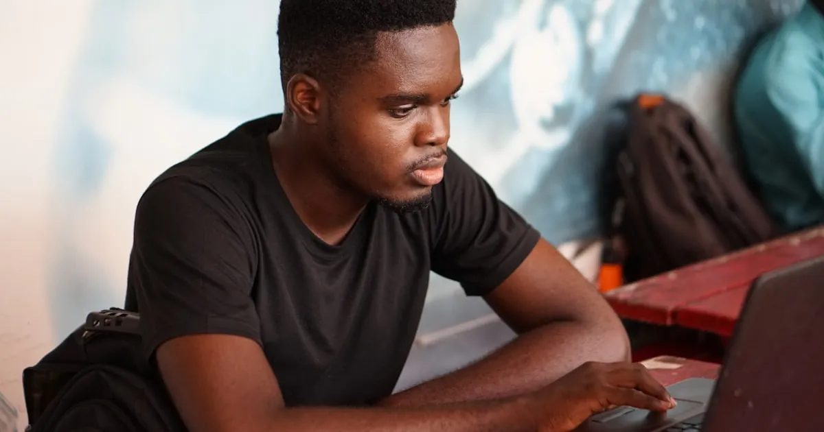 Student studying with laptop and headphones in a lecture setting