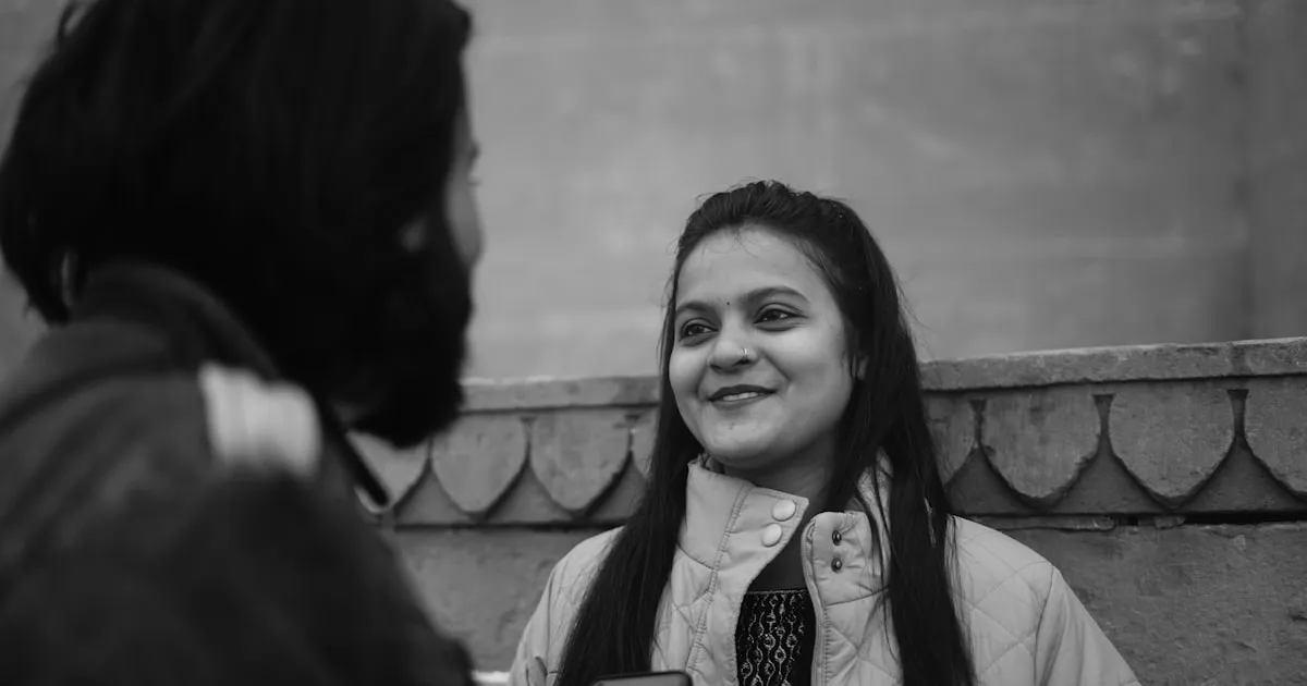 Two people in a research interview setting with a recorder on the table